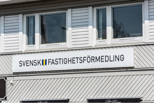 En fasad med en skylt som det står Svensk Fastighetsförmedling.